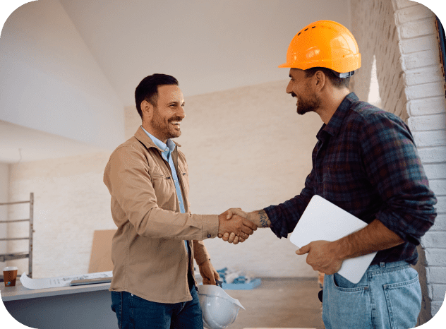 Two men shaking hands in construction site.