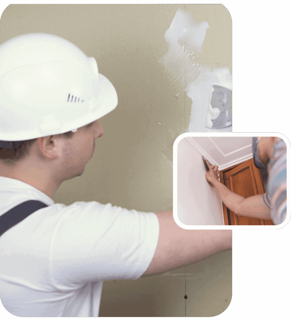 Worker applying drywall compound with trowel.