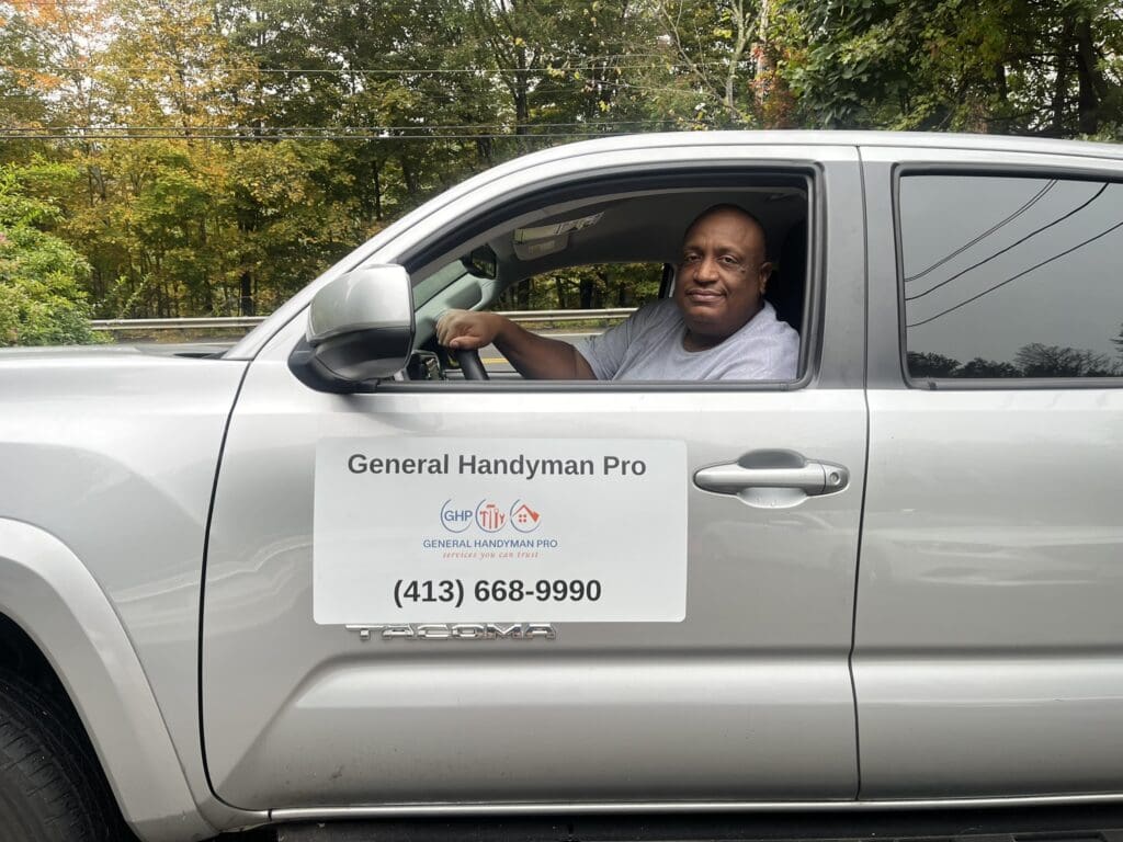 Man driving truck with handyman service sign.